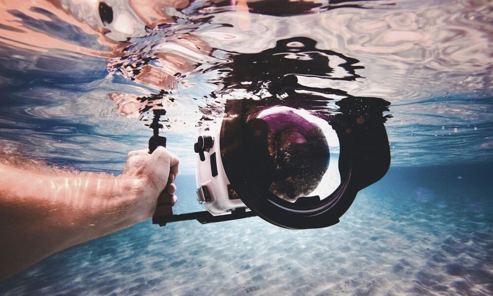 A person's hand holding a camera